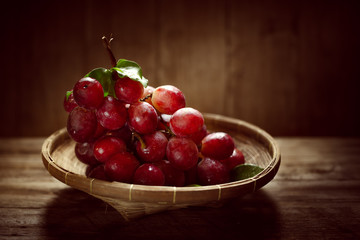 Bunches of fresh ripe red grapes on a wooden textural surface ancient style a beautiful