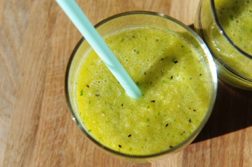 Green smoothies in a glass with a straw