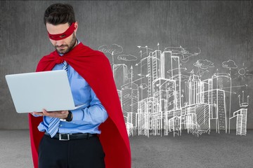 Businessman in super hero costume using laptop