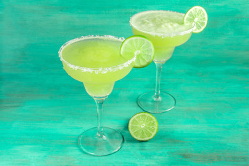 Lemon Margarita cocktails on vibrant teal with copyspace