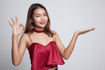Beautiful young Asian woman show palm hand and OK sign.