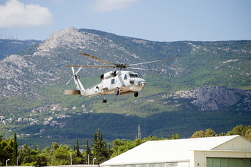 Black hawk helicopter rescue team.exhaust gas, approach landing,mountain background