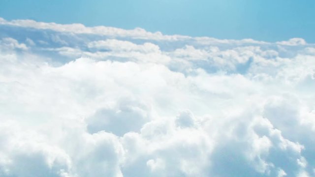 CGI 3D animation of flying above white fluffy clouds on bright day