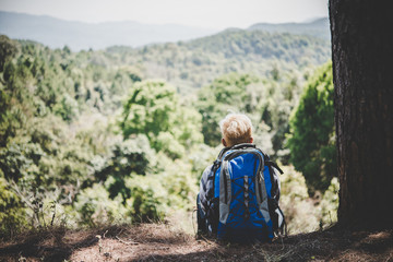 Obraz premium Young man hiking sitting relax and admire nature.