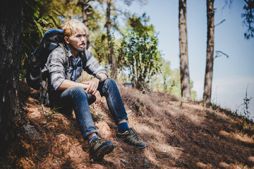 Naklejka na ściany i meble Young man hiking sitting relax and admire nature.