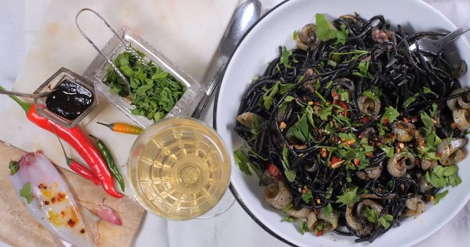 Dolly top down view of delivious black pasta with squids (cuttlefish) and ink