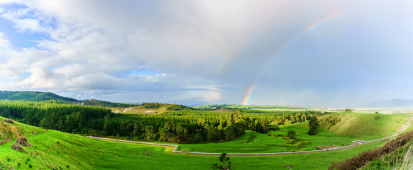 Panoramic scenery of active geothermal area in New Zealand's Taupo Volcanic Zone with double rainbow , North Island of New Zealand