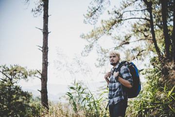Young man standing the middle of the forest on the hill.