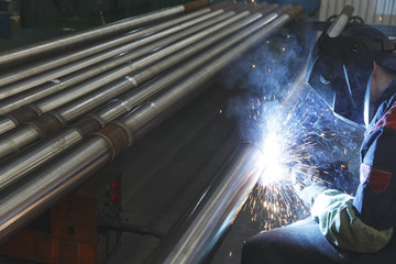 Welder electrically welds metal pipes, Selective focus