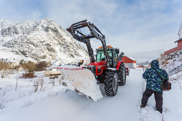 The snow-plow tractor on the road