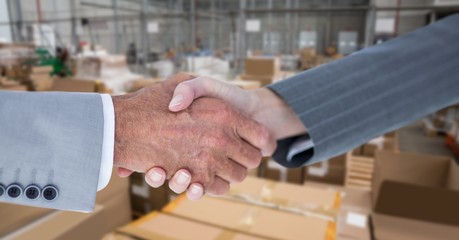 Cropped image of business people doing handshake in warehouse