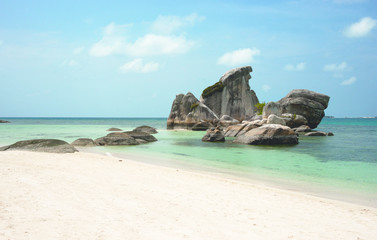 Natural rock formation in the sea and on a white sand beach in Belitung Island in the afternoon, Indonesia.