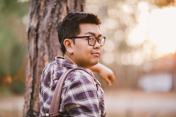 A male traveller with his sunglasses and backpack in the pine forest, Thailand