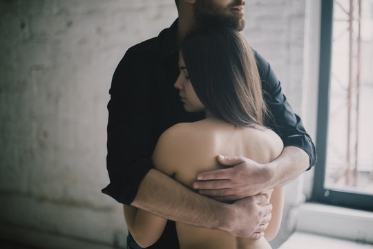 Caucasian man hugging woman with bare back