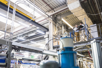 Two men talking in factory shop floor