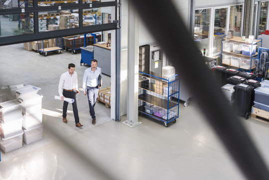 Two businessmen walking in factory shop floor