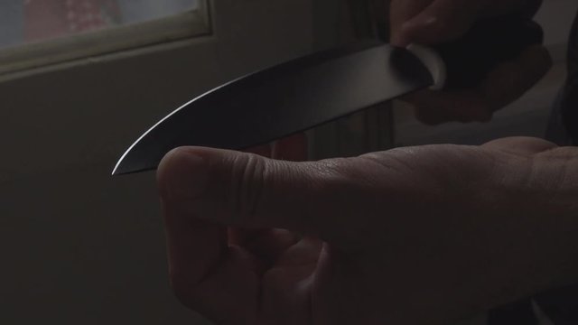 Psychopath holding sharp knife in hands, close up