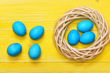 traditional eggs painted in blue color inside woven wooden wreath