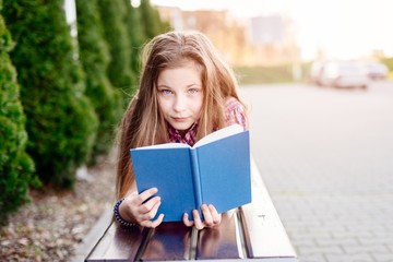 Fototapeta premium Ten years old blue eye blonde girl reading book