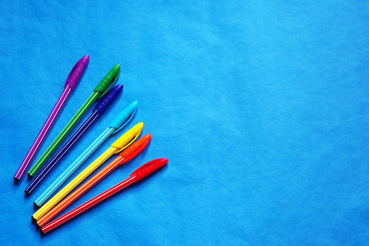 Colored pens on a blue background