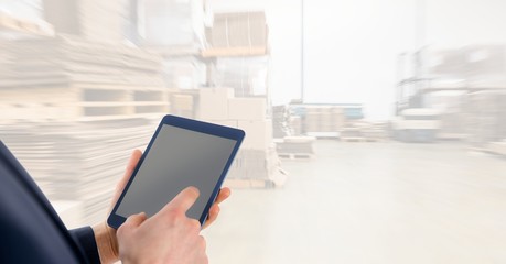 Midsection businessman using digital tablet in warehouse