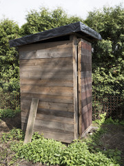 Rustic dry wc. A wooden rural building for excommunication. Funny scenery from the garden.