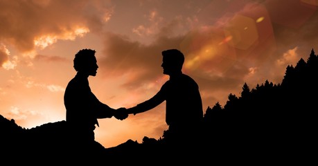Silhouette businessmen shaking hands during sunset