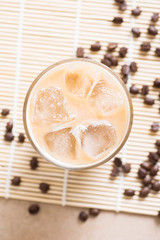 Glass of ice coffee with coffee bean on wooden background