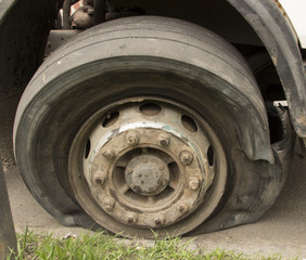 Flat tire of an old fragment of a rusty broken truck