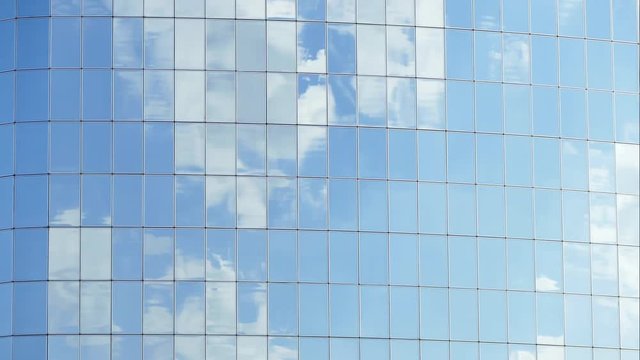 Clouds reflected in windows of modern office building