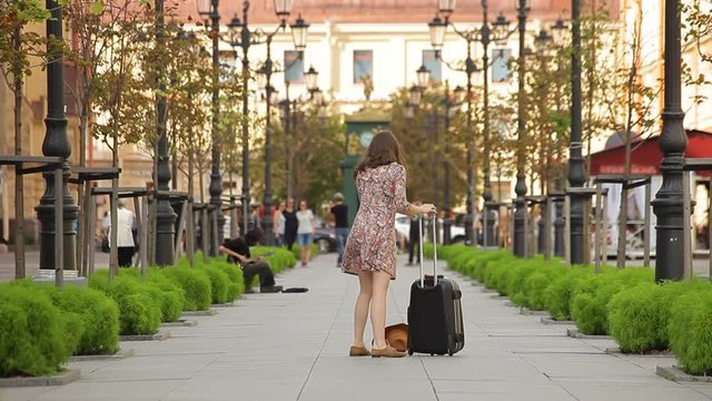 Young Woman With Suitcase Walking Down the Street in a European City