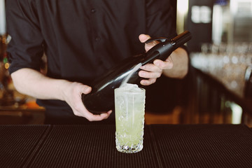 Barman's hands in bar interior making non-alcohol cocktail
