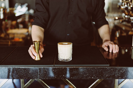 Close up of hands of barman making espresso in glass