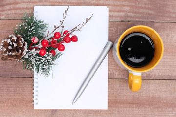 Pen and Notepad on the wooden desk. And cup of tea or coffee.