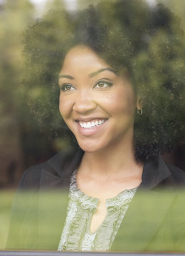 Smiling Black woman behind window