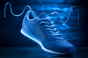 Blue sport sneakers on a wooden background