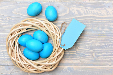 traditional eggs painted in blue color inside woven wooden wreath