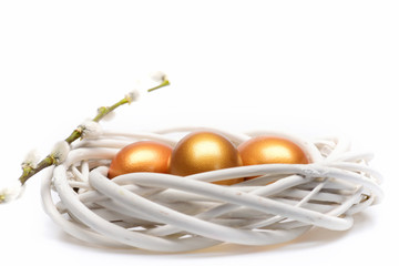 traditional eggs painted in golden color inside woven wooden wreath
