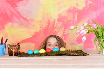 Fototapeta na wymiar happy easter girl with pencils, colorful eggs and tulip flowers