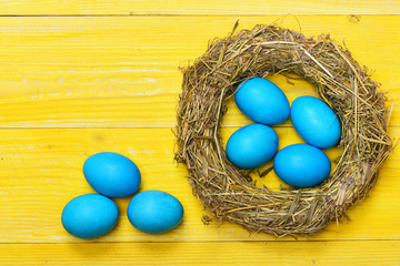 traditional eggs painted in blue color inside woven straw wreath