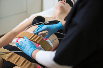 Woman receiving slimming lipo laser therapy in spa