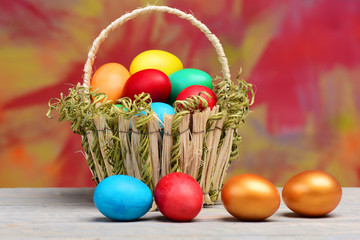 spring easter holiday, colorful eggs and golden egg in basket