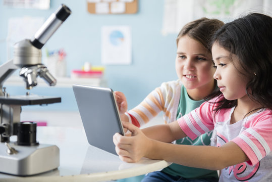 Girls using digital tablet in classroom