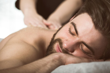 Fototapeta na wymiar Man relaxing during a salt scrub beauty therapy