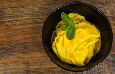 Sweet pumpkin ravioli with banana on a wooden background. top view.