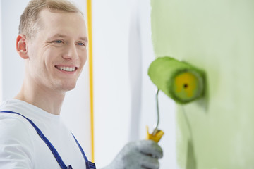 Blond painter painting the wall