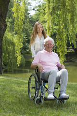 Woman with elderly man on a wheelchair