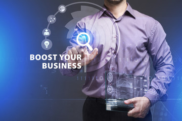 Business, Technology, Internet and network concept. Young businessman working on a virtual screen of the future and sees the inscription: Boost your business