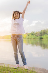 young beautiful woman relaxing in park nearby lake