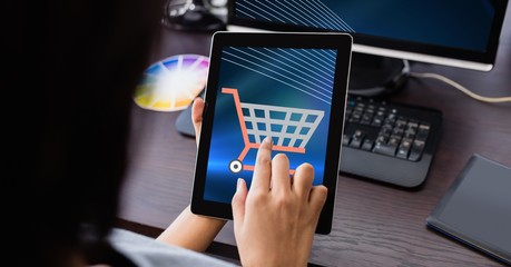 Hand touching shopping cart icon on tablet PC
